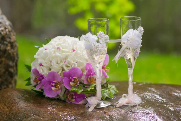 Zwei Hochzeitsgläser und Brautstrauß im Sommergarten — Stockfoto
