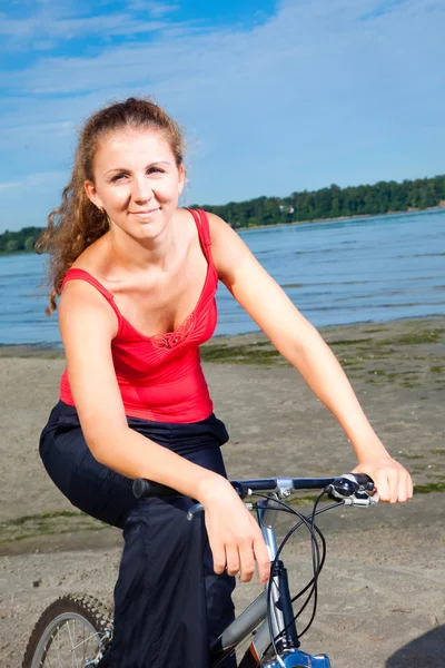 Hermosa mujer con bicicleta en el mar — Foto de Stock