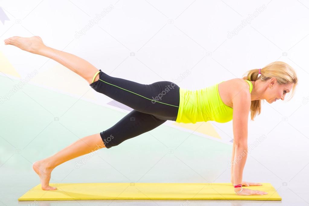 beautiful pilates instructor with yellow yoga mat