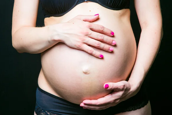 Barriga grávida com as mãos da mãe — Fotografia de Stock