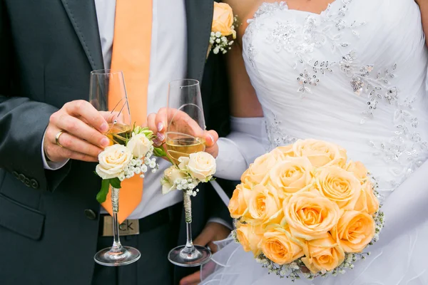 Handen van bruid en bruidegom bruiloft boeket en glazen — Stockfoto