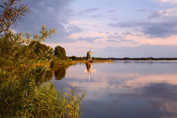 Wiatrak holenderski nad jeziorem — Zdjęcie stockowe