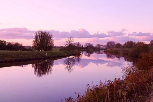 Pôr do sol sobre o canal em terras agrícolas — Fotografia de Stock