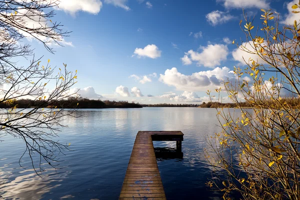 Sonbaharda büyük göl üzerinde ahşap iskele — Stok fotoğraf
