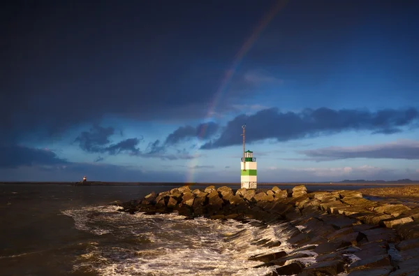 Lighthouse and rainbow over sea — Stock Photo, Image