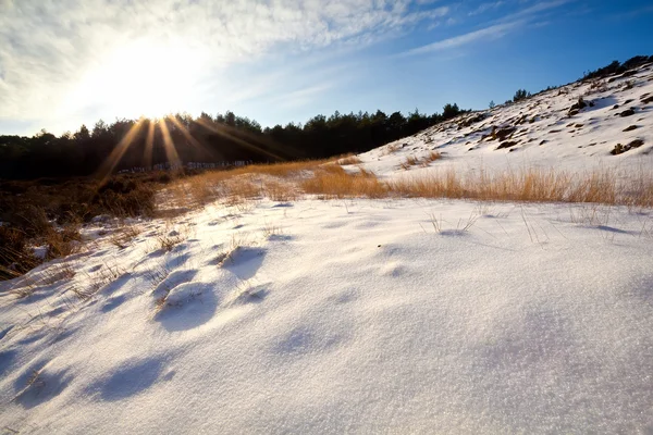 Solstrålar över snö kullar — Stockfoto