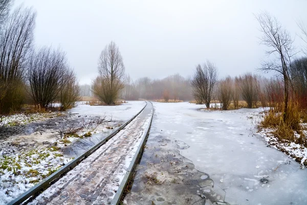Holzstraßenbrücke durch zugefrorenen See — Stockfoto
