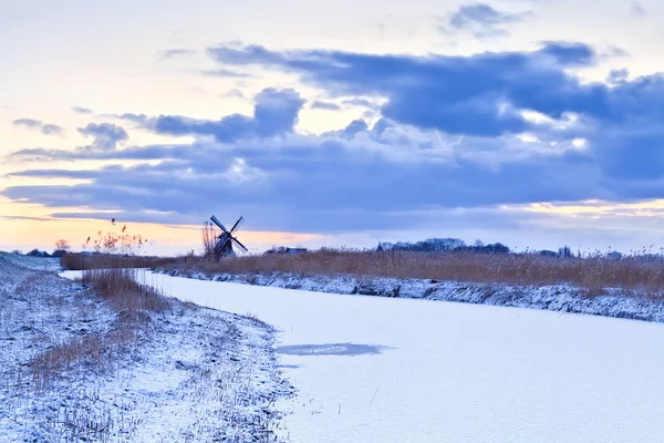 Moinho de vento holandês no inverno ao nascer do sol — Fotografia de Stock