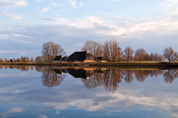 Dutch farmhouse by river before sunset — Stock Photo, Image