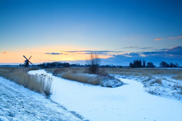 Mulino a vento sul fiume ghiacciato all'alba, Groninga — Foto Stock