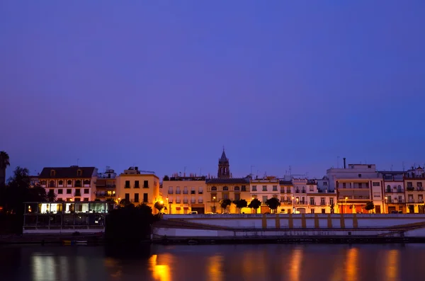 Paisaje urbano de Sevilla por río al atardecer — Foto de Stock