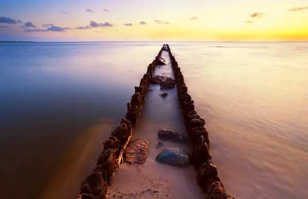 Long wooden dike in North sea at sunset — Stock Photo, Image