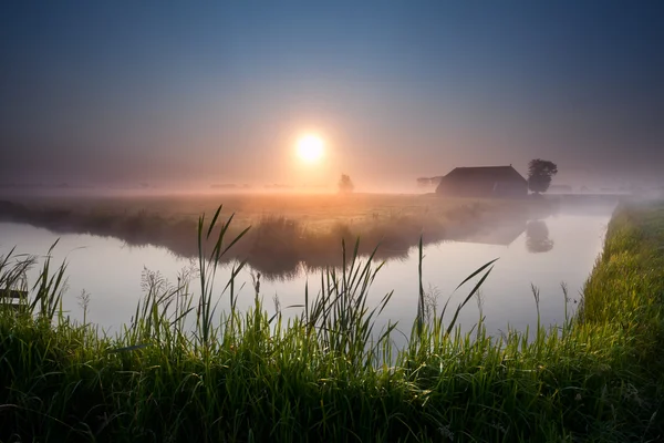 Nebuloso amanecer sobre el río en las tierras de labrantío —  Fotos de Stock