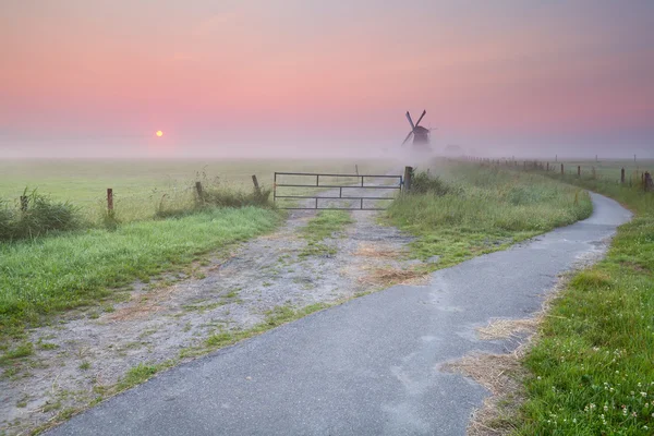 Radweg zur Windmühle im Nebel — Stockfoto