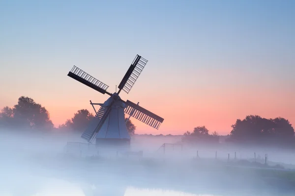 Encantador molino de viento holandés en la niebla de la mañana — Foto de Stock