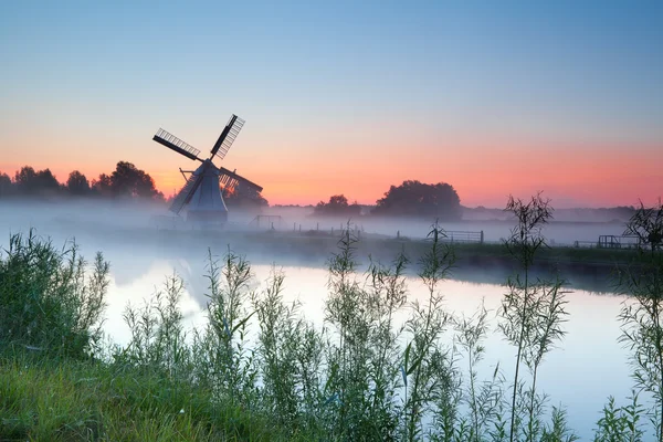 Nederlandse witte windmolen bij zonsopgang — Stockfoto