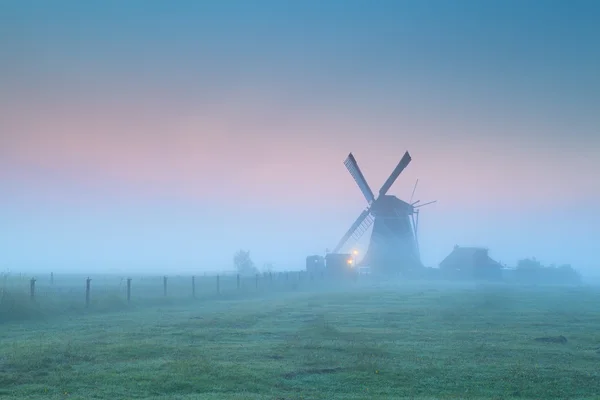 Windmill in fog at sunrise — Stock Photo, Image