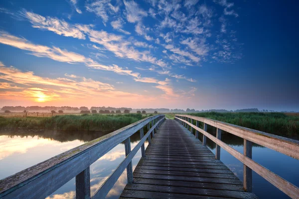 Pont en bois sur la rivière au lever du soleil — Photo