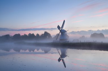 sunrise, sabah sis içinde büyüleyici Hollanda Yeldeğirmeni