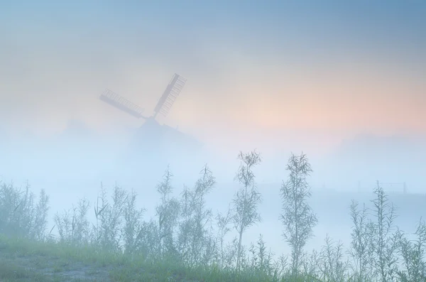 Dutch windmill in dense sunrise fog — Stock Photo, Image