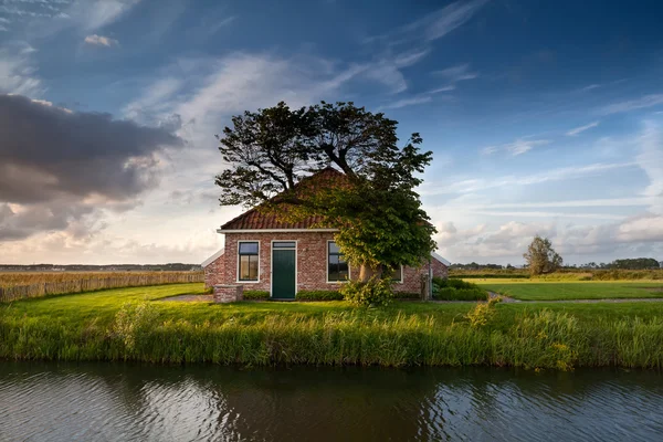 Charming farmhouse by river — Stock Photo, Image