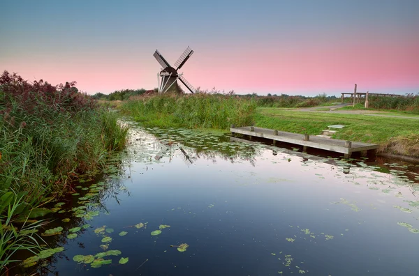 Molino de viento holandés por río al amanecer —  Fotos de Stock