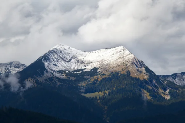 Besneeuwde bergtop in wolken — Stockfoto