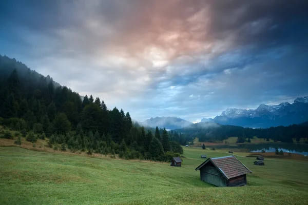 Misty sunrise over huts by Geroldsee lake — Stock Photo, Image