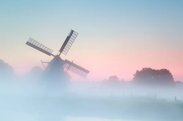 Charming Dutch windmill in dense sunrise fog — Stock Photo, Image