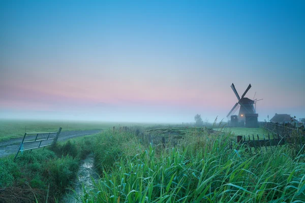 Východ slunce nad nizozemskou zemědělskou půdou s větrným mlýnem — Stock fotografie