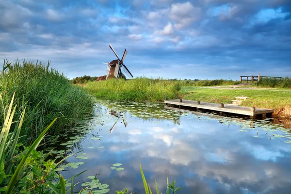 Ciel bleu et moulin à vent reflétés dans la rivière — Photo