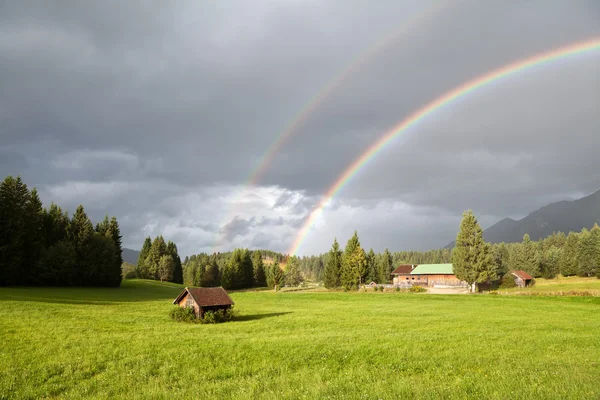Красочная радуга во время дождя в Альпах — стоковое фото