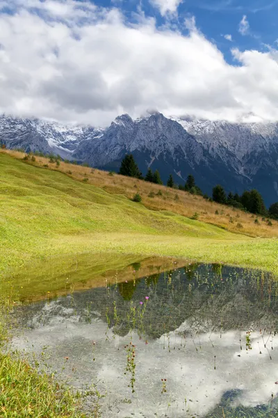 Berge in Wolken spiegeln sich im See — Stockfoto