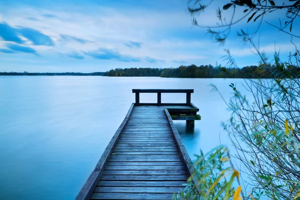 Träbrygga på stora sjön med lång exponering — Stockfoto