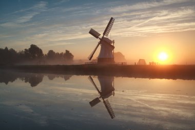 sunrise behind Dutch windmill clipart