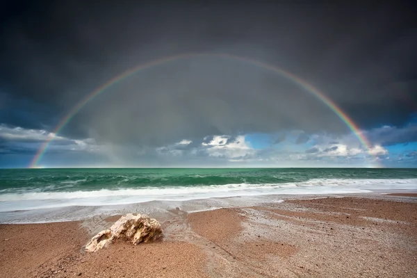 Arco iris sobre playa de piedra en el océano Atlántico —  Fotos de Stock