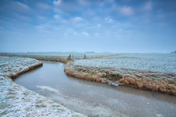 Hollanda tarım arazileri üzerinde donmuş canal — Stok fotoğraf