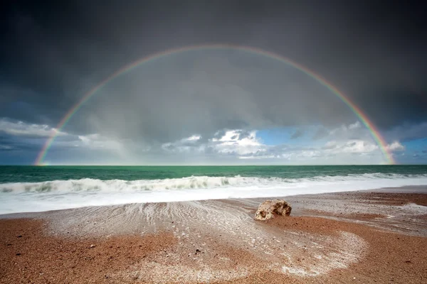 Big beautiful rainbow over ocean waves — Stock Photo, Image