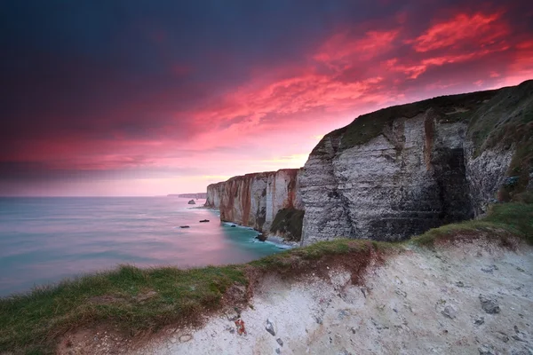 Dramatic fire sunrise over cliffs in ocean — Stock Photo, Image