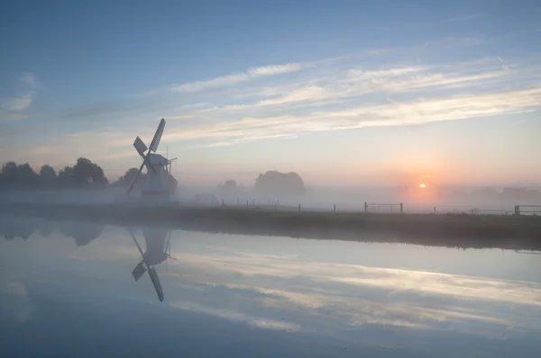 Misty sunrise over river and windmill — Stock Photo, Image