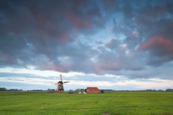 Zonsopgang boven de molen op Nederlandse landbouwgrond — Stockfoto