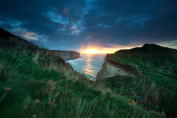 Solnedgång solsken över klippor i havet — Stockfoto