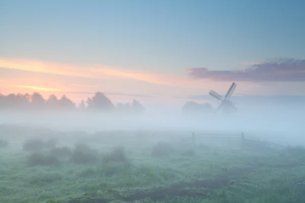 Силуэт ветряной мельницы в густом утреннем тумане — стоковое фото