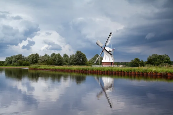 Weiße Windmühle über bewölktem Himmel — Stockfoto