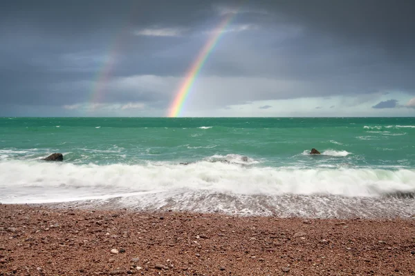 Beautiful rainbow over ocean coast — Stock Photo, Image