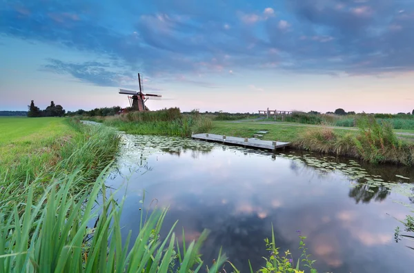 Windmühle am Fluss bei Sonnenuntergang — Stockfoto