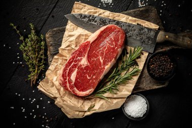 Siyah arka planda baharatlı, sulu, çiğ kaburga.