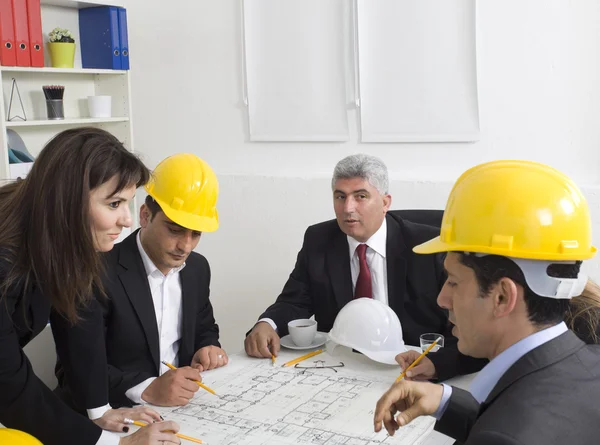 Architects sitting at table and looking at a project — Stock Photo, Image