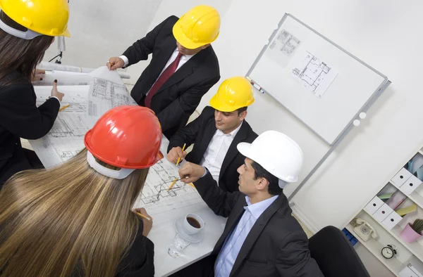 Boven weergave van architecten zitten aan de tafel en des te bespreken — Stockfoto