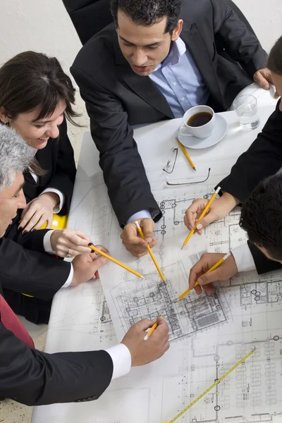 Vista superior de los arquitectos sentados a la mesa y discutiendo des — Foto de Stock